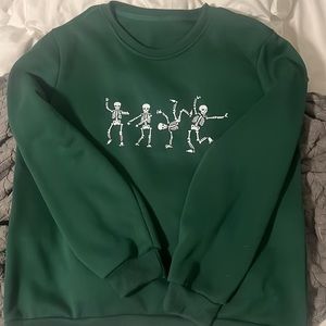 forest green sweatshirt with dancing skeletons